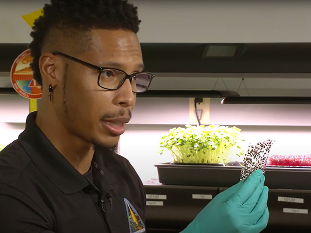 Dr. Matthew Mickens, a NASA horticulturist, holding a piece of seed film