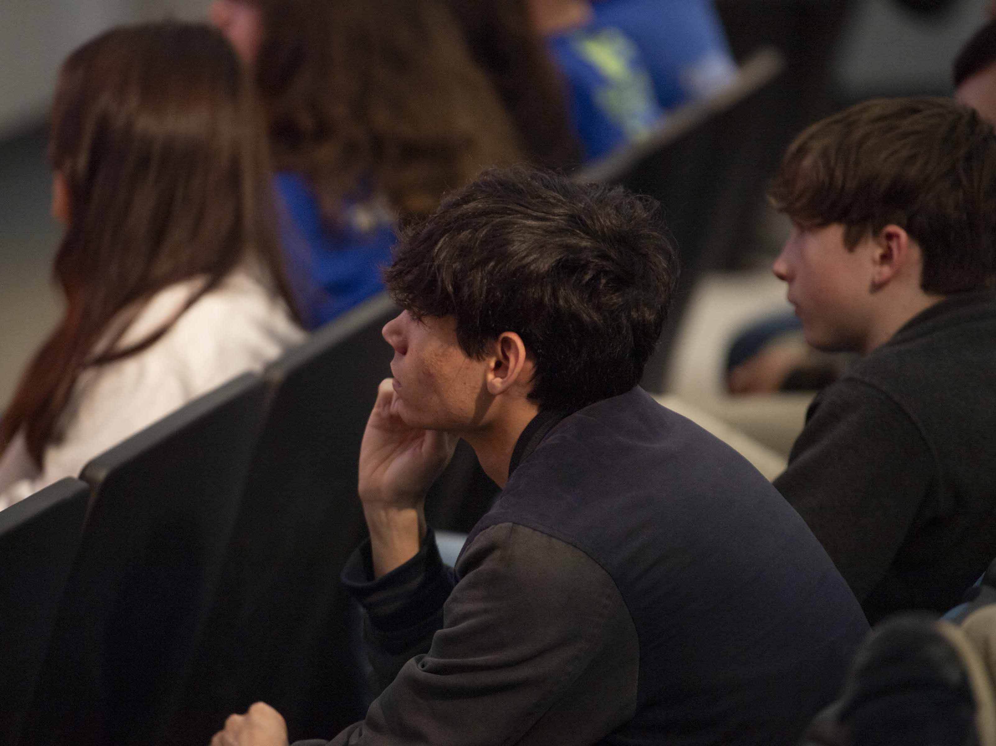 a student leaning forward as he listens to speakers during a Next Gen STEM Explore Stennis event