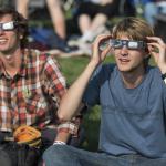 People are seen as they watch a total solar eclipse through protective glasses in Madras, Oregon on Monday, Aug. 21, 2017. A total solar eclipse swept across a narrow portion of the contiguous United States from Lincoln Beach, Oregon to Charleston, South Carolina.