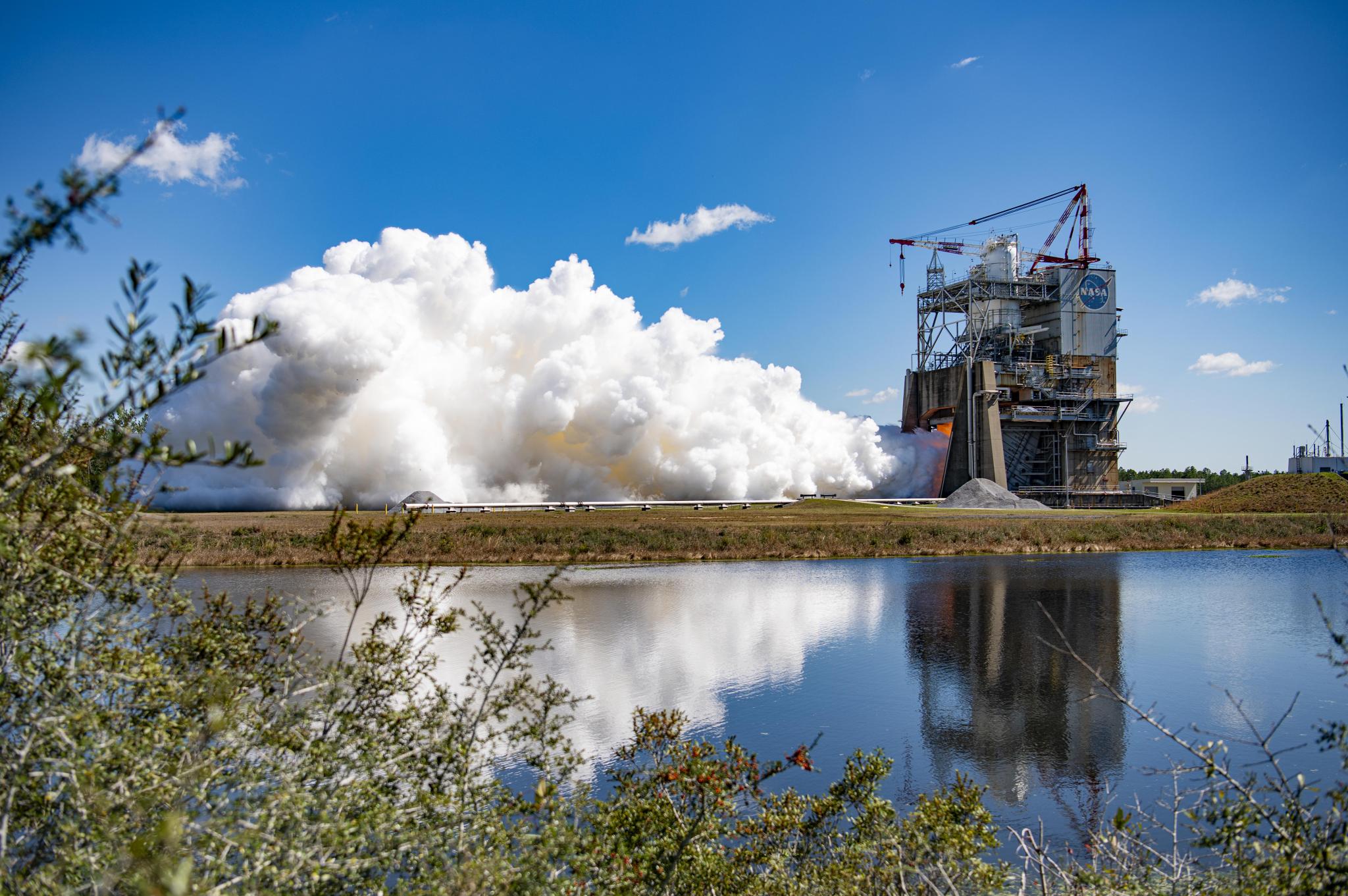 full-duration RS-25 engine hot fire is seen in the background