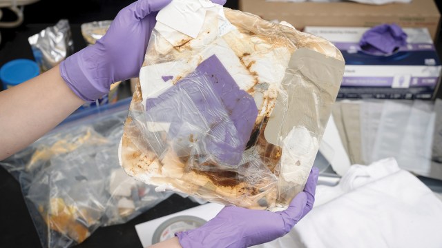 a block of compacted trash held by gloved hands