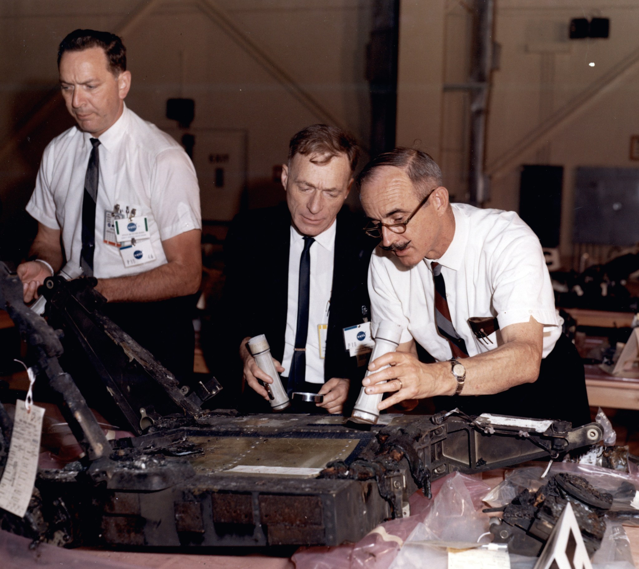 Three men looking at equipment.