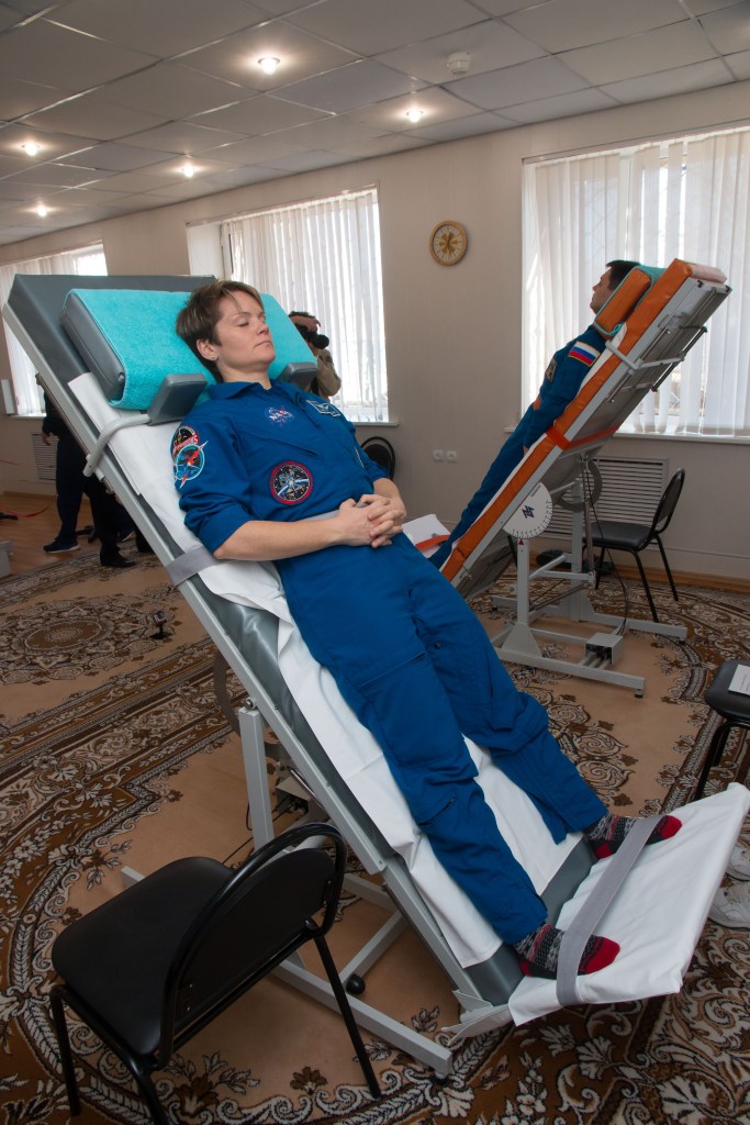 jsc2018e097773 - At the Cosmonaut Hotel crew quarters in Baikonur, Kazakhstan, Expedition 58 crew member Anne McClain of NASA conducts vestibular system response training on a tilt table Nov. 27 as part of pre-launch training. McClain, David Saint-Jacques of the Canadian Space Agency and Oleg Kononenko of Roscosmos will launch Dec. 3 on the Soyuz MS-11 spacecraft from the Baikonur Cosmodrome in Kazakhstan for a six-and-a-half month mission on the International Space Station...NASA/Victor Zelentsov