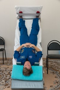 jsc2018e097774 - At the Cosmonaut Hotel crew quarters in Baikonur, Kazakhstan, Expedition 58 crew member Anne McClain of NASA conducts vestibular system response training on a tilt table Nov. 27 as part of pre-launch training. McClain, David Saint-Jacques of the Canadian Space Agency and Oleg Kononenko of Roscosmos will launch Dec. 3 on the Soyuz MS-11 spacecraft from the Baikonur Cosmodrome in Kazakhstan for a six-and-a-half month mission on the International Space Station...NASA/Victor Zelentsov