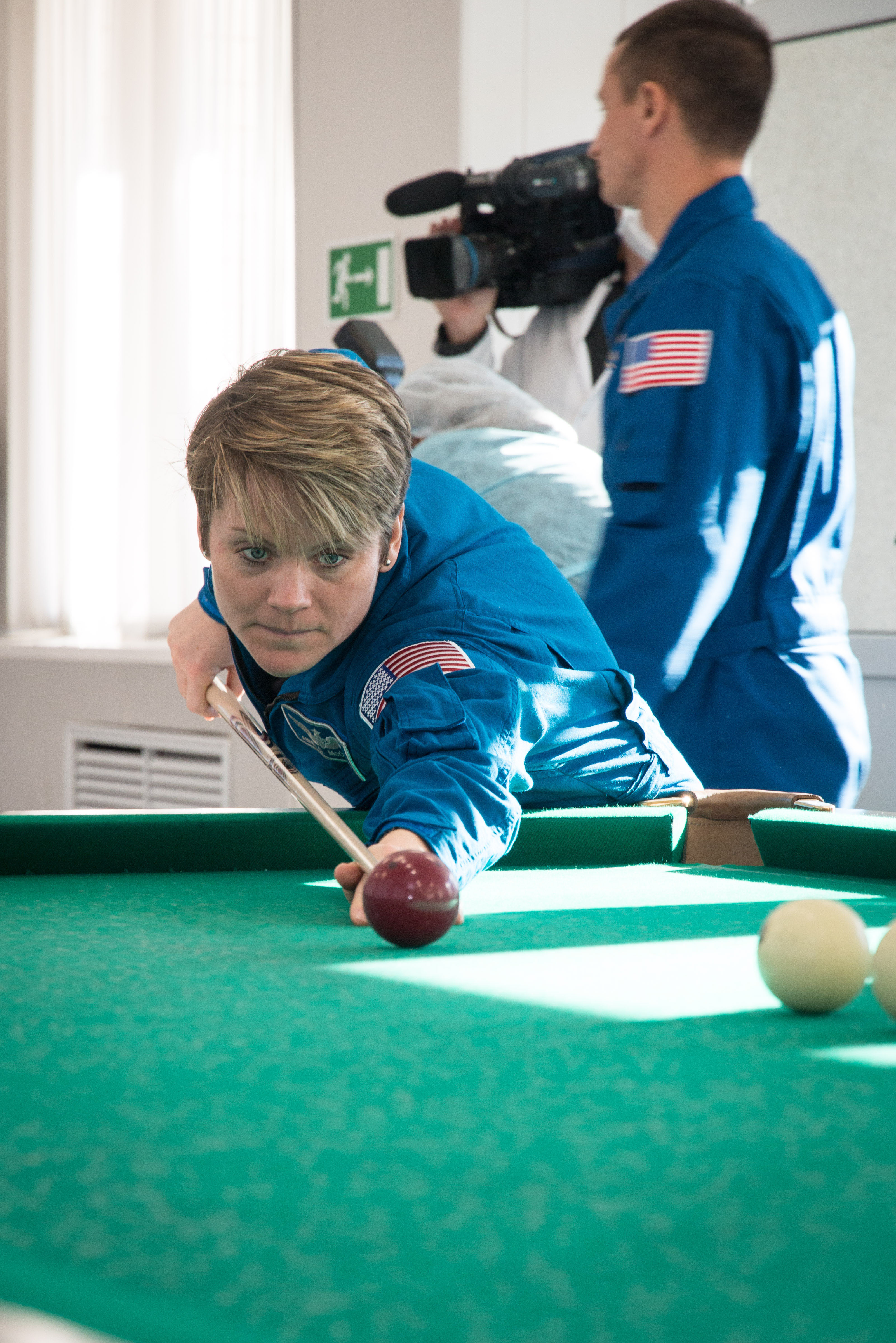 jsc2018e097769 - At her Cosmonaut Hotel crew quarters in Baikonur, Kazakhstan, Expedition 58 crew member Anne McClain of NASA tries her hand at a game of billiards Nov. 27 during free time from pre-launch training. McClain, David Saint-Jacques of the Canadian Space Agency and Oleg Kononenko of Roscosmos will launch Dec. 3 on the Soyuz MS-11 spacecraft from the Baikonur Cosmodrome in Kazakhstan for a six-and-a-half month mission on the International Space Station...NASA/Victor Zelentsov