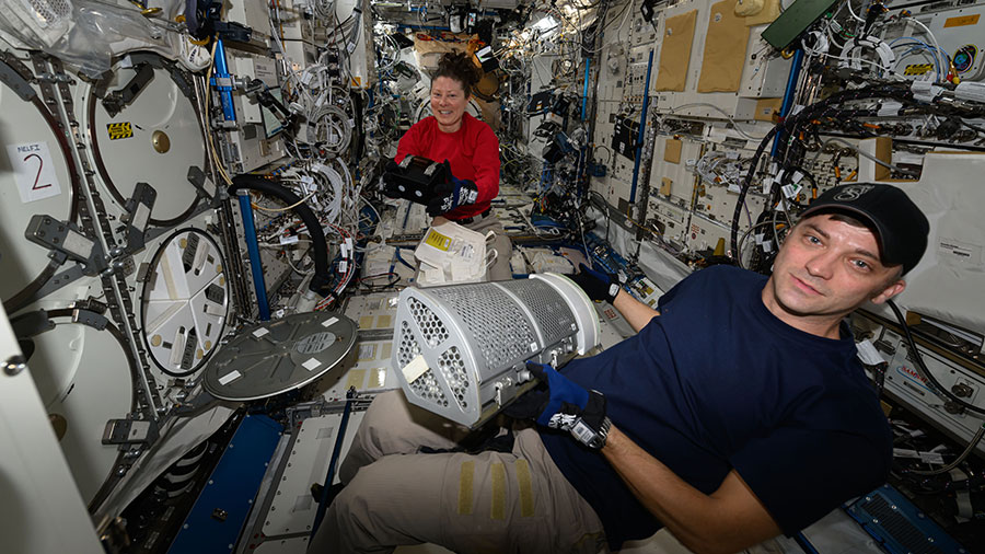 Astronauts Tracy C. Dyson and Matthew Dominick collect research samples preserved inside science freezers for transferring inside the SpaceX Dragon cargo spacecraft.