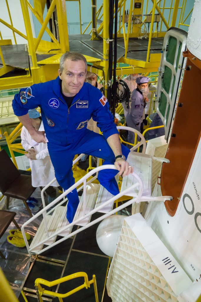 jsc2018e098091 - In the Integration Facility at the Baikonur Cosmodrome in Kazakhstan, Expedition 58 crew member David Saint-Jacques of the Canadian Space Agency prepares to climb aboard the Soyuz MS-11 spacecraft Nov. 29 during a final vehicle fit check. Saint-Jacques, Anne McClain of NASA and Oleg Kononenko of Roscosmos will launch Dec. 3 in the Soyuz MS-11 spacecraft from the Baikonur Cosmodrome in Kazakhstan for a six-and-a-half month mission on the International Space Station...NASA/Victor Zelentsov