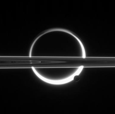 As it orbited Saturn, in November 2009 Cassini imaged eclipses of moons Titan, center, and Enceladus, lower right of Titan, and the planet’s rings