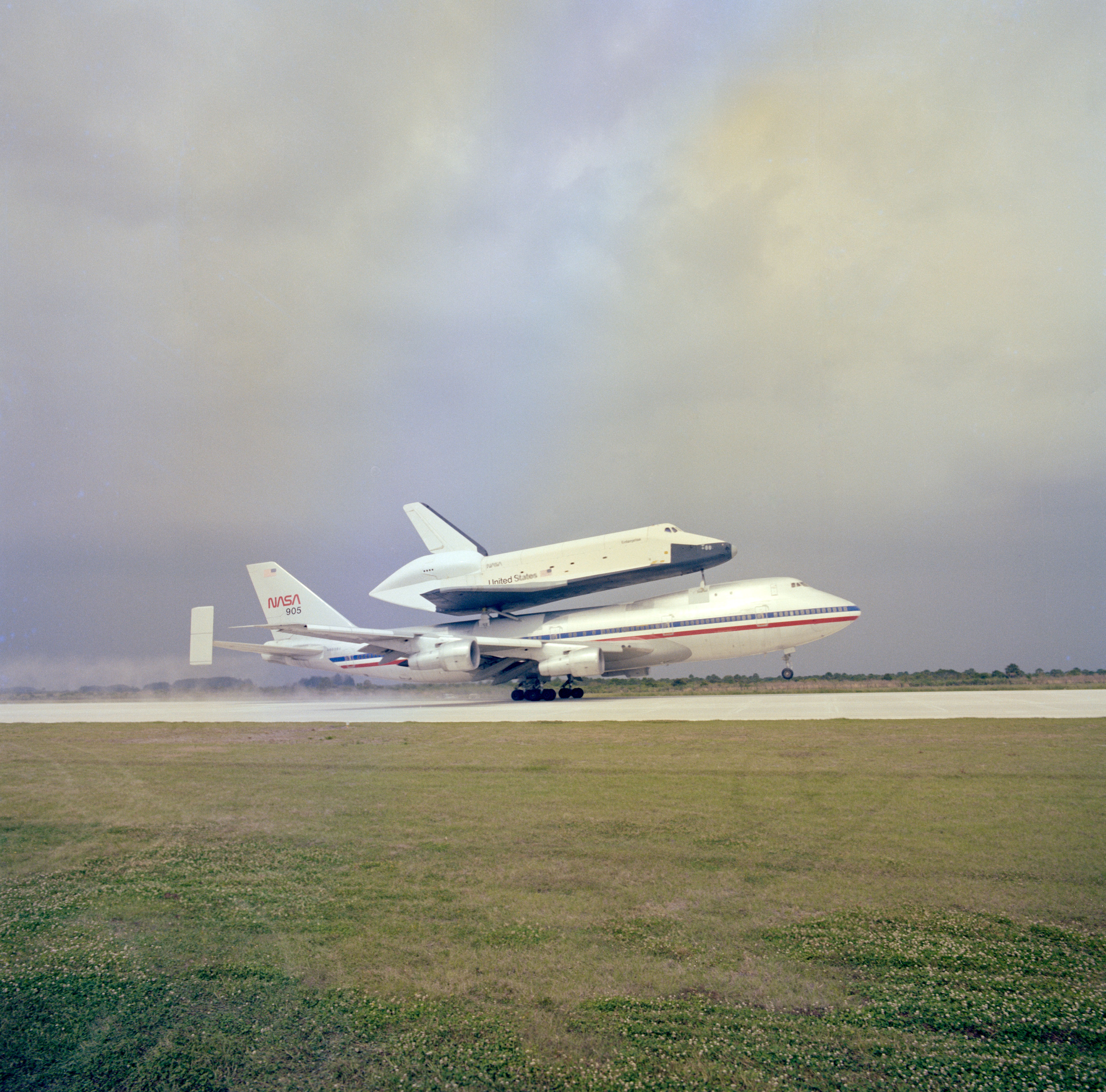 In January 1977, workers trucked Enterprise 36 miles overland from Palmdale to NASA's Dryden, now Armstrong, Flight Research Center at Edwards Air Force Base (AFB) in California, for the ALT program, a series of increasingly complex flights to evaluate the shuttle's air worthiness. At Dryden, workers placed Enterprise on the back of the Shuttle Carrier Aircraft (SCA), a modified Boeing 747. The duo began taxi runs in February, followed by the first captive inactive flight later that month. The first captive active flight with a crew aboard the orbiter took place in June, and Enterprise made its first independent flight on Aug. 12 with Haise and Fullerton at the controls. Four additional approach and landing flights completed the ALT program by October. In March 1978, Enterprise began its first cross-country trip. Riding atop the SCA, Enterprise left Edwards, and after a weekend stopover at Houston's Ellington AFB, arrived at the Redstone Arsenal's airfield in Huntsville, Alabama. Workers trucked Enterprise to the adjacent NASA Marshall Space Flight Center where engineers for the first time mated it with an External Tank (ET) and inert Solid Rocket Boosters (SRB) in the Dynamic Structural Test Facility. For the next year, engineers conducted a series of vibration tests on the combined vehicle, simulating conditions expected during an actual launch.