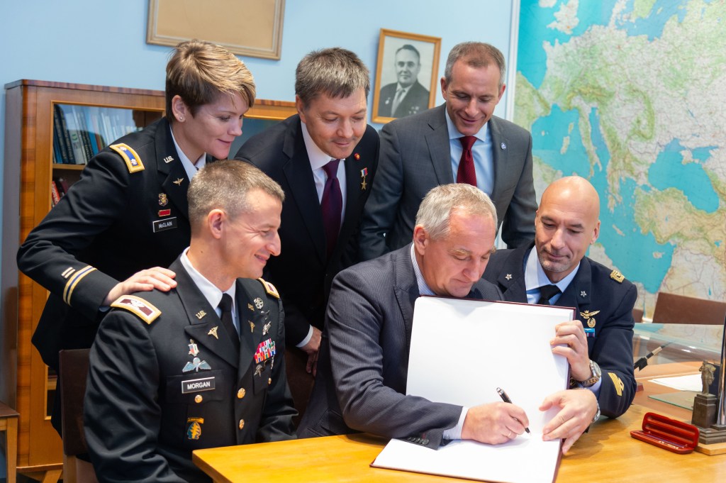jsc2018e096935 (Nov. 15, 2018) --- At the Gagarin Museum at the Gagarin Cosmonaut Training Center in Star City, Russia, Expedition 58 backup crew members Drew Morgan of NASA (front row, left), Alexander Skvortsov of Roscosmos (front row, center) and Luca Parmitano of the European Space Agency (front row, right) sign a book bearing crews’ signatures in a traditional ceremony Nov. 15. Looking on in the back row are the prime crew members, Anne McClain of NASA (left), Oleg Kononenko of Roscosmos (center) and David Saint-Jacques of the Canadian Space Agency (right), who will launch Dec. 3 on the Soyuz MS-11 spacecraft from the Baikonur Cosmodrome in Kazakhstan for a six-and-a-half month mission on the International Space Station...NASA/Sarah Volkman