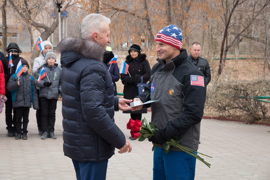 jsc2018e097314 - In the town of Baikonur, Kazakhstan, Expedition 58 backup crew member Drew Morgan of NASA (right) accepts a traditional present from a local official Nov. 21 as part of pre-launch activities. Morgan is one of the backups to Anne McClain of NASA, Oleg Kononenko of Roscosmos and David Saint-Jacques of the Canadian Space Agency, who will launch Dec. 3 on the Soyuz MS-11 spacecraft from the Baikonur Cosmodrome in Kazakhstan for a six-and-a-half month mission on the International Space Station...NASA/Victor Zelentsov