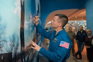 jsc2018e097322 - At the Baikonur Museum in the town of Baikonur, Kazakhstan, Expedition 58 backup crew member Drew Morgan of NASA signs a wall mural Nov. 21 in a traditional pre-launch activity. He is one of the backups to Anne McClain of NASA, Oleg Kononenko of Roscosmos and David Saint-Jacques of the Canadian Space Agency, who will launch Dec. 3 on the Soyuz MS-11 spacecraft from the Baikonur Cosmodrome in Kazakhstan for a six-and-a-half month mission on the International Space Station...NASA/Victor Zelentsov
