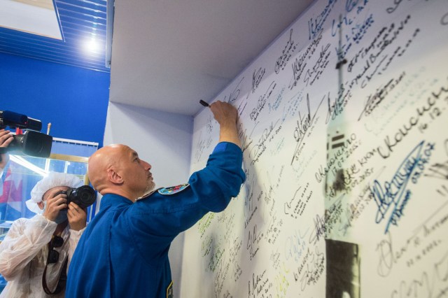 jsc2019e039433 (July 16, 2019) --- At the Baikonur Cosmodrome in Kazakhstan, Expedition 60 crewmember Luca Parmitano of the European Space Agency signs a wall mural July 16 as part of pre-launch preparations. Parmitano, Drew Morgan of NASA and Alexander Skvortsov of Roscosmos will launch July 20 on the Soyuz MS-13 spacecraft from the Baikonur Cosmodrome for a mission on the International Space Station. Credit: Andrey Shelepin/GCTC