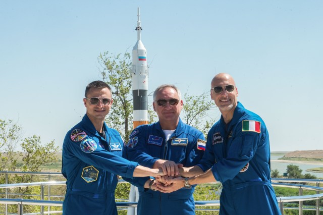 jsc2019e039260 (July 12, 2019) --- At the Cosmonaut Hotel crew quarters in Baikonur, Kazakhstan, Expedition 60 crewmembers Drew Morgan of NASA (left), Alexander Skvortsov of Roscosmos (center) and Luca Parmitano of the European Space Agency (right) pose for pictures July 12 as part of pre-launch activities. They will launch July 20 on the Soyuz MS-13 spacecraft from the Baikonur Cosmodrome in Kazakhstan on a mission to the International Space Station. Credit: Andrey Shelepin/GCTC