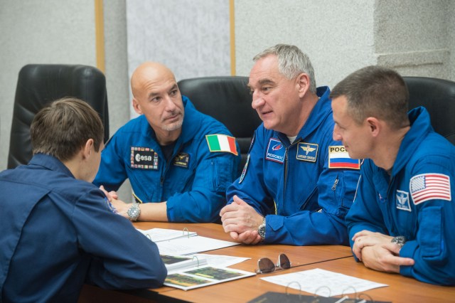 jsc2019e039270 (July 12, 2019) --- At the Cosmonaut Hotel crew quarters in Baikonur, Kazakhstan, Expedition 60 crewmembers Luca Parmitano of the European Space Agency (left), Alexander Skvortsov of Roscosmos (center) and Drew Morgan of NASA (right) review flight plan procedures with instructors July 12 as part of pre-launch activities. They will launch July 20 on the Soyuz MS-13 spacecraft from the Baikonur Cosmodrome in Kazakhstan on a mission to the International Space Station. Credit: Andrey Shelepin/GCTC