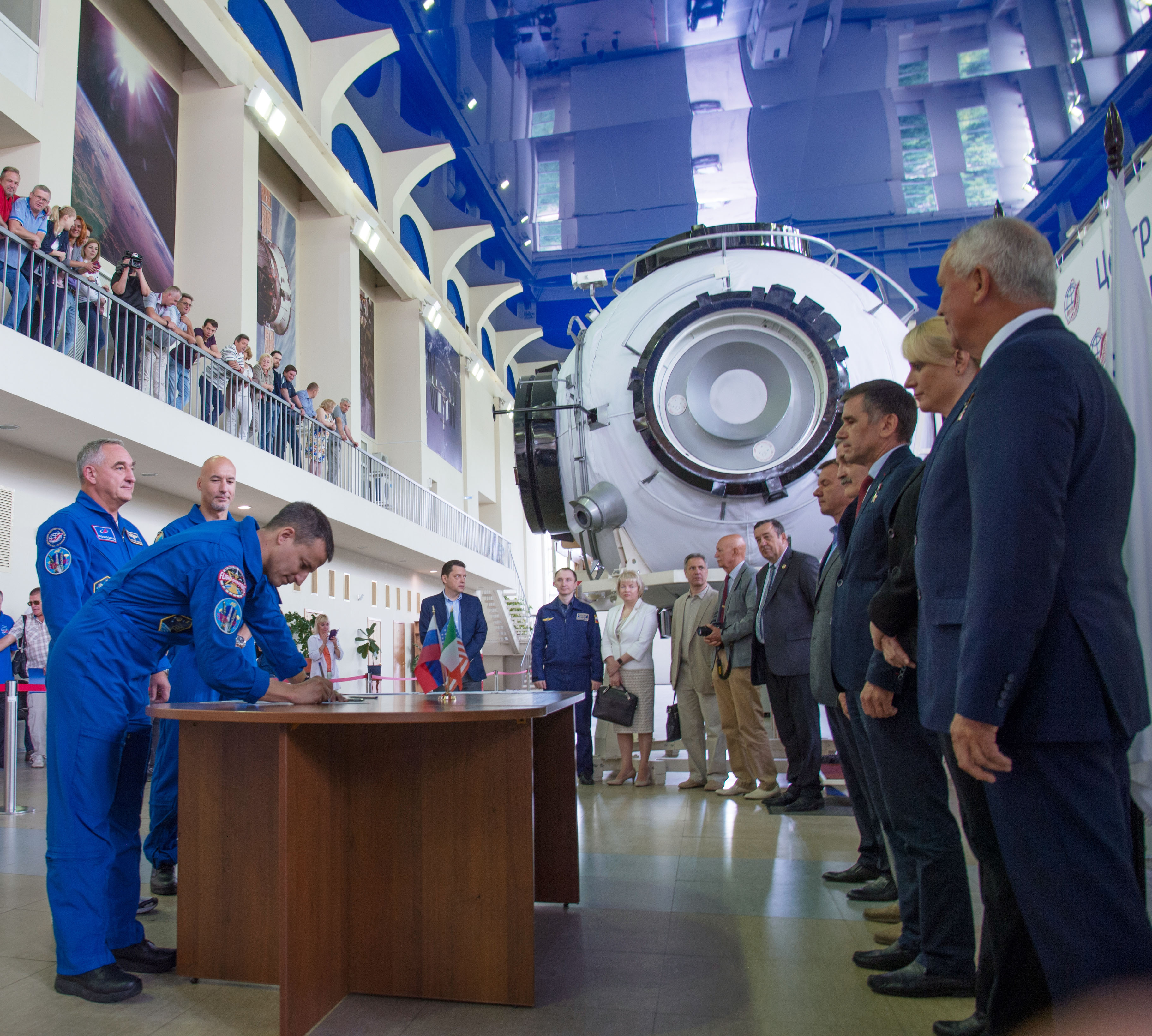 jsc2019e035255 (June 26, 2019) --- At the Gagarin Cosmonaut Training Center in Star City, Russia, Expedition 60 crewmember Drew Morgan of NASA signs in June 26 for the first day of final qualification exams. Looking on are crewmates Alexander Skvortsov of Roscosmos and Luca Parmitano of the European Space Agency. They will launch July 20 on the Soyuz MS-13 spacecraft from the Baikonur Cosmodrome in Kazakhstan for a mission on the International Space Station. Credit: NASA/Beth Weissinger