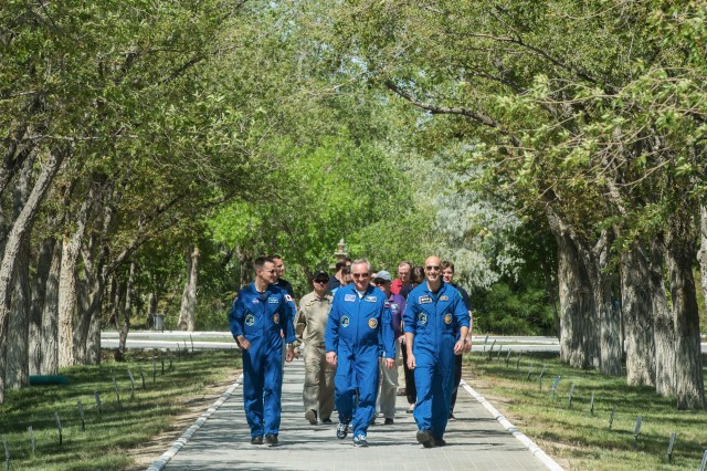 jsc2019e039263 (July 12, 2019) --- At the Cosmonaut Hotel crew quarters in Baikonur, Kazakhstan, Expedition 60 crewmembers Drew Morgan of NASA (left), Alexander Skvortsov of Roscosmos (center) and Luca Parmitano of the European Space Agency (right) stroll down the Walk of the Cosmonauts July 12 as part of pre-launch activities. They will launch July 20 on the Soyuz MS-13 spacecraft from the Baikonur Cosmodrome in Kazakhstan on a mission to the International Space Station. Credit: Andrey Shelepin/GCTC