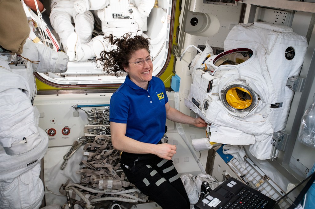 iss060e000808 (June 26, 2019) --- Expedition 60 Flight Engineer Christina Koch of NASA works on a U.S. spacesuit in the Quest airlock where U.S. spacewalks are staged aboard the International Space Station.