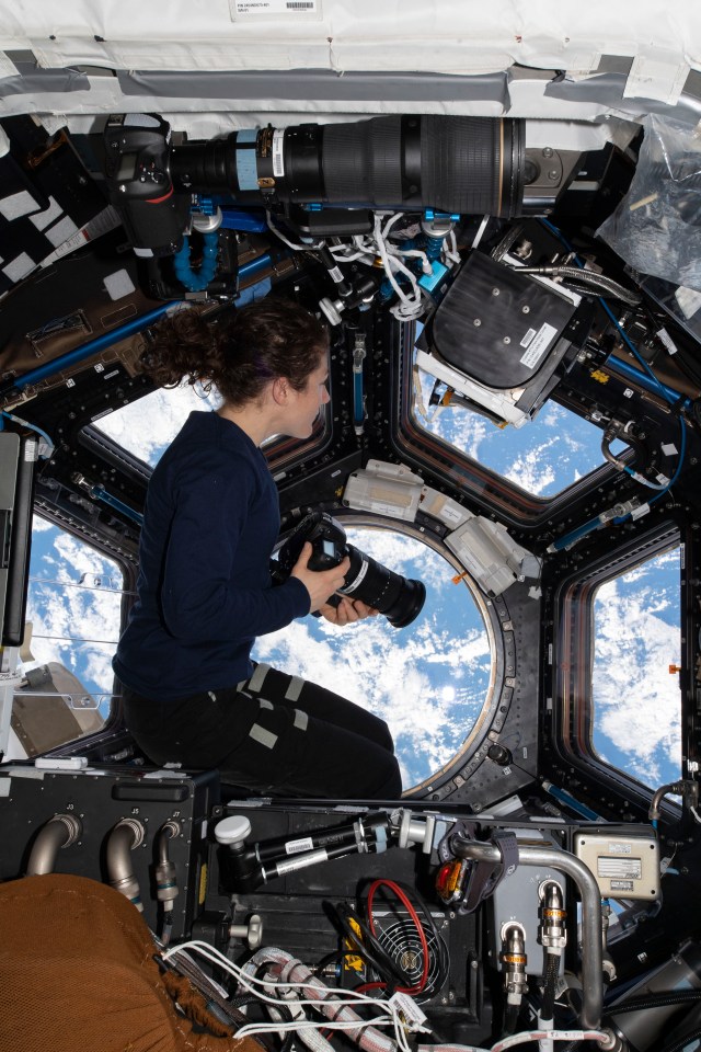 iss060e033385 (Aug. 11, 2019) --- Expedition 60 Flight Engineer Christina Koch of NASA looks through the station's "window to the world," the seven-windowed cupola. Koch was photographing landmarks as the orbiting lab flew 259 miles above the Pacific Ocean off the coast of South America.