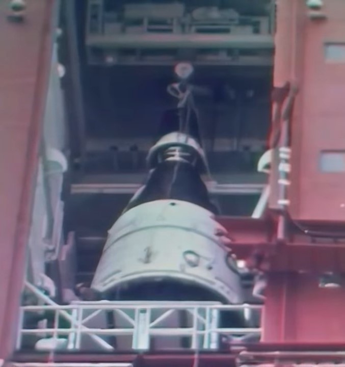 Workers lower Gemini 1 onto its Titan II rocket