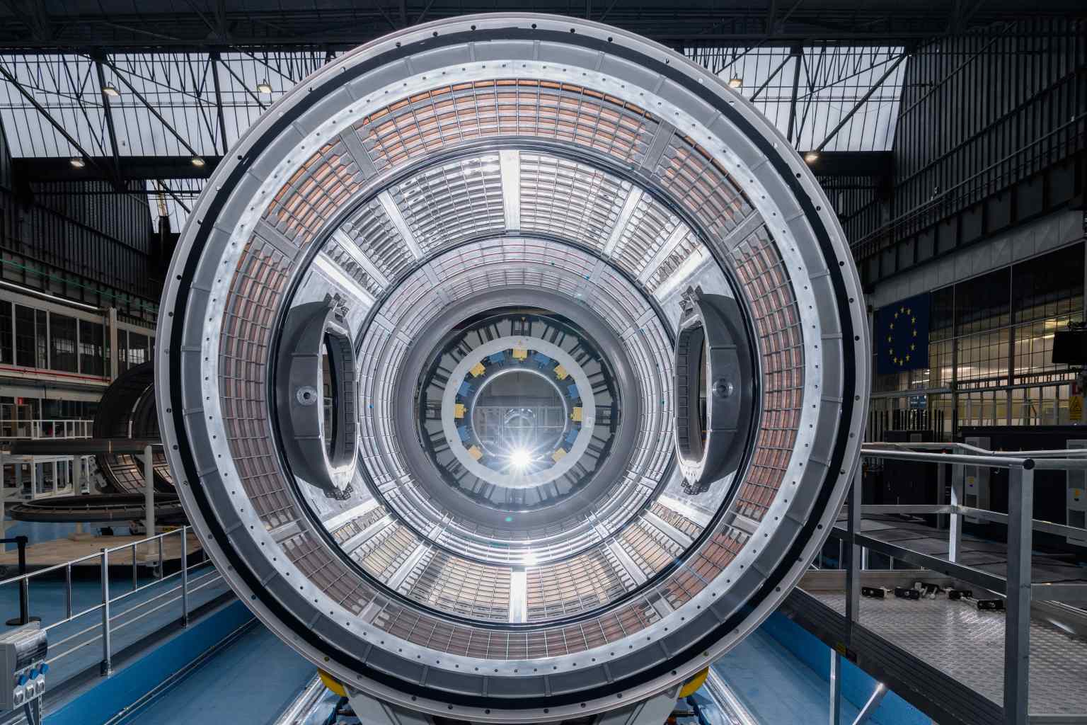 A large circular structure stands in a facility. The camera looks straight through the structure. At this angle, the interior looks like concentric circles.