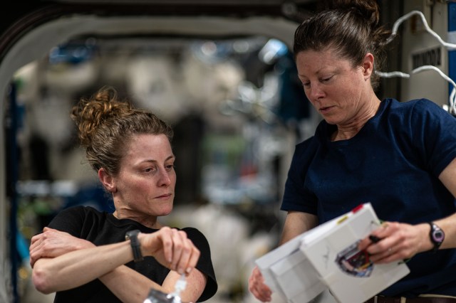 Expedition 70 Flight Engineers (from left) Loral O'Hara and Tracy C. Dyson, both NASA astronauts, review documents aboard the International Space Station.