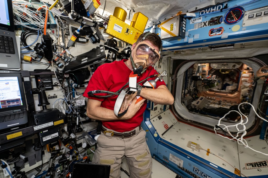 Expedition 71 Flight Engineer and NASA astronaut Matthew Dominick tests portable breathing gear aboard the International Space Station's Destiny laboratory module.