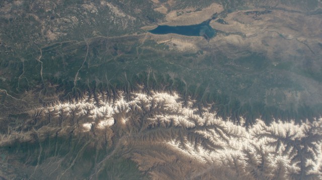 The snow-capped Caucasus Mountains run through Azerbaijan and Russia in this photograph from the International Space Station as it orbited 258 miles above. At top, is the Mingachevir Reservoir, the largest reservoir in the Caucasus and used for fishing, water supplies, and irrigation.