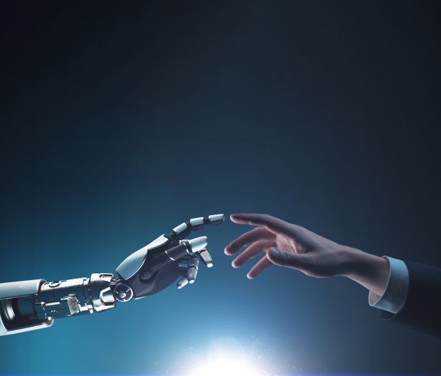 Human hand touching robotic hand