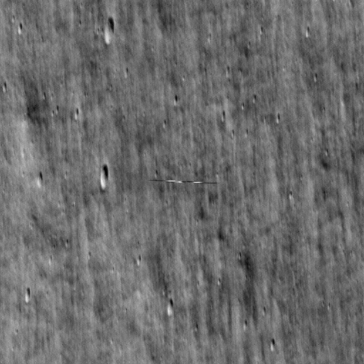 grayscale view of lunar surface with a smeared streak in the center of the image