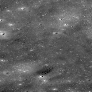 grayscale view of lunar surface with a dark smudge in the center of the image