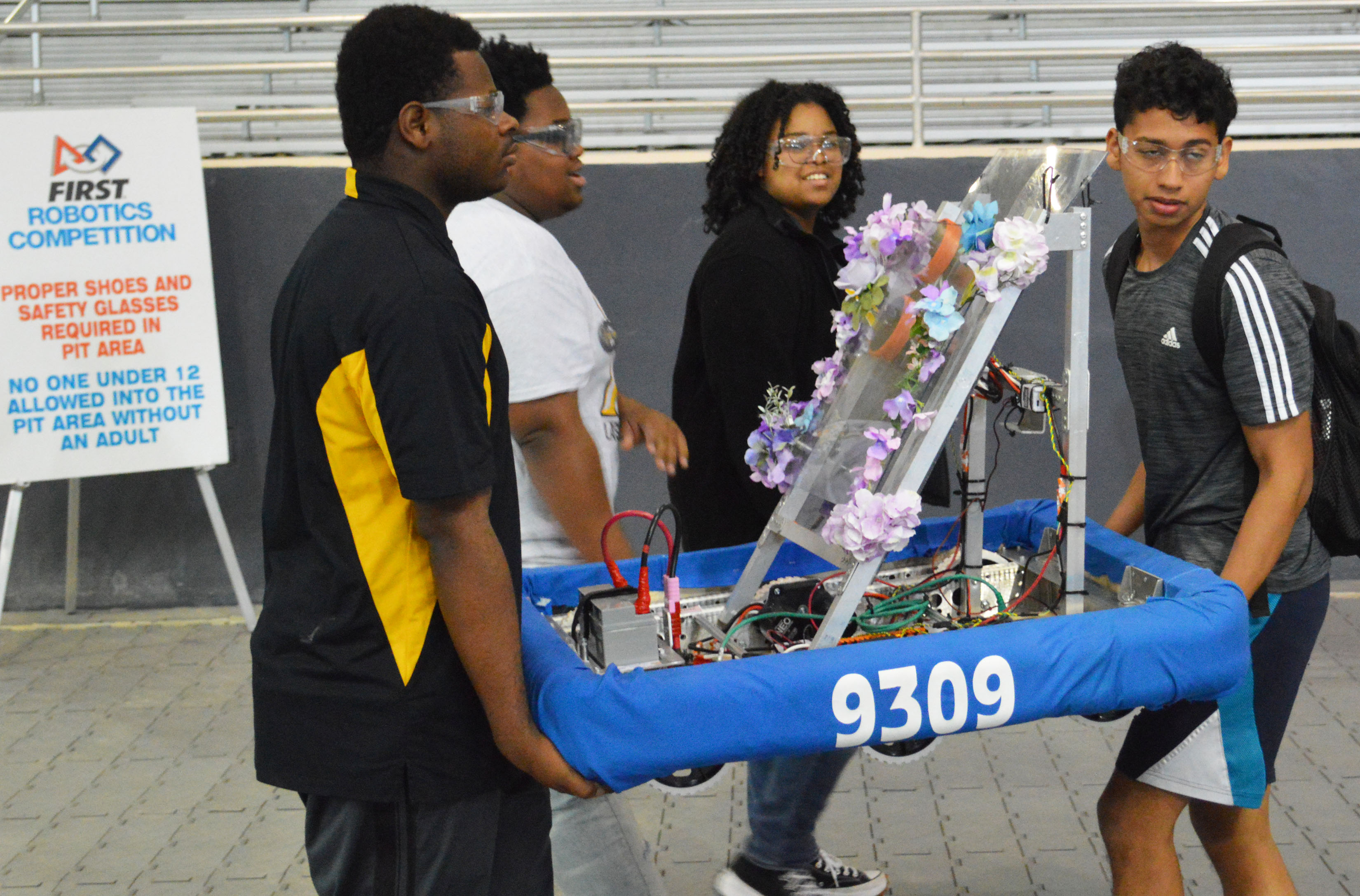 a team escorts their robot to the competition floor