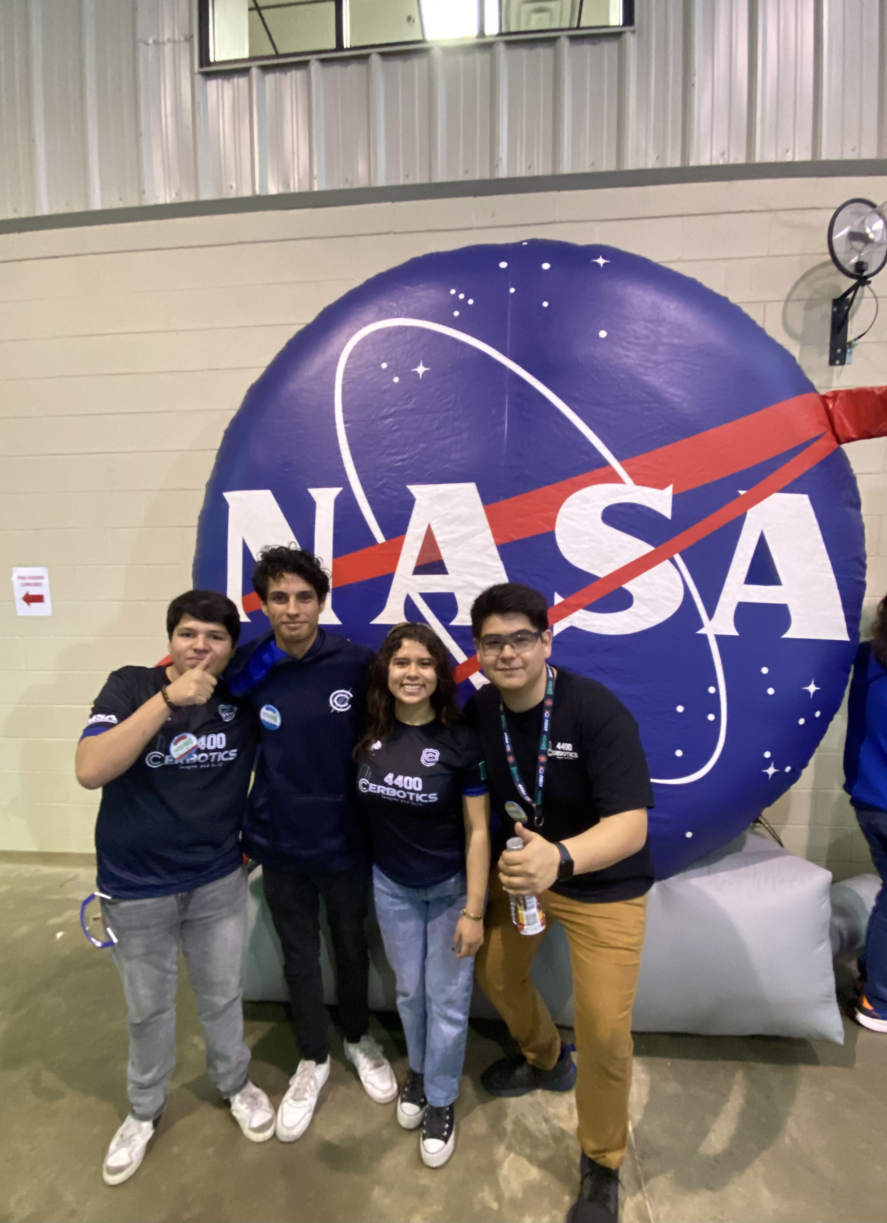 students pose in front of the NASA meatball inflatable