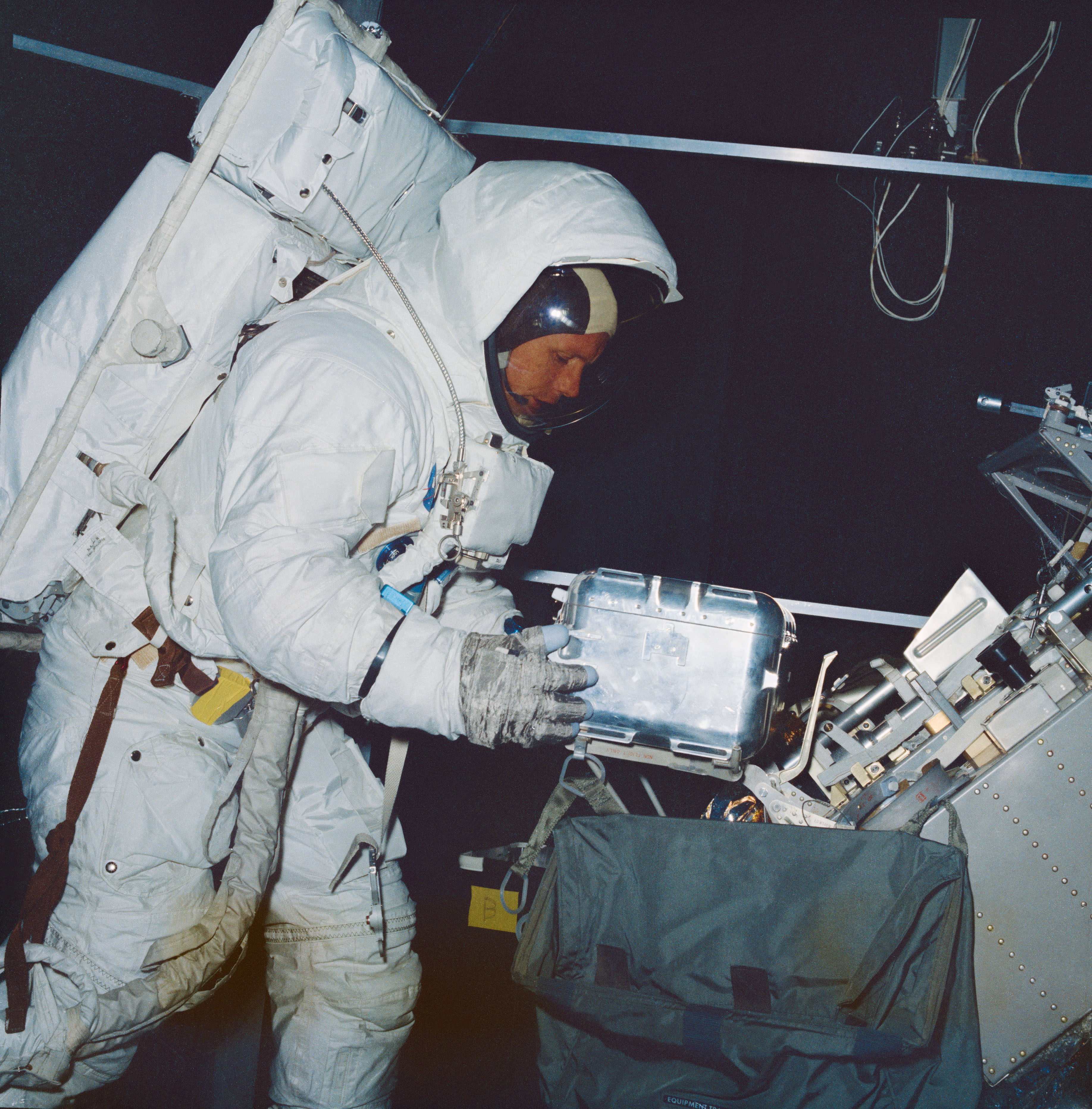 Neil A. Armstrong trains with a lunar sample container in a vacuum chamber