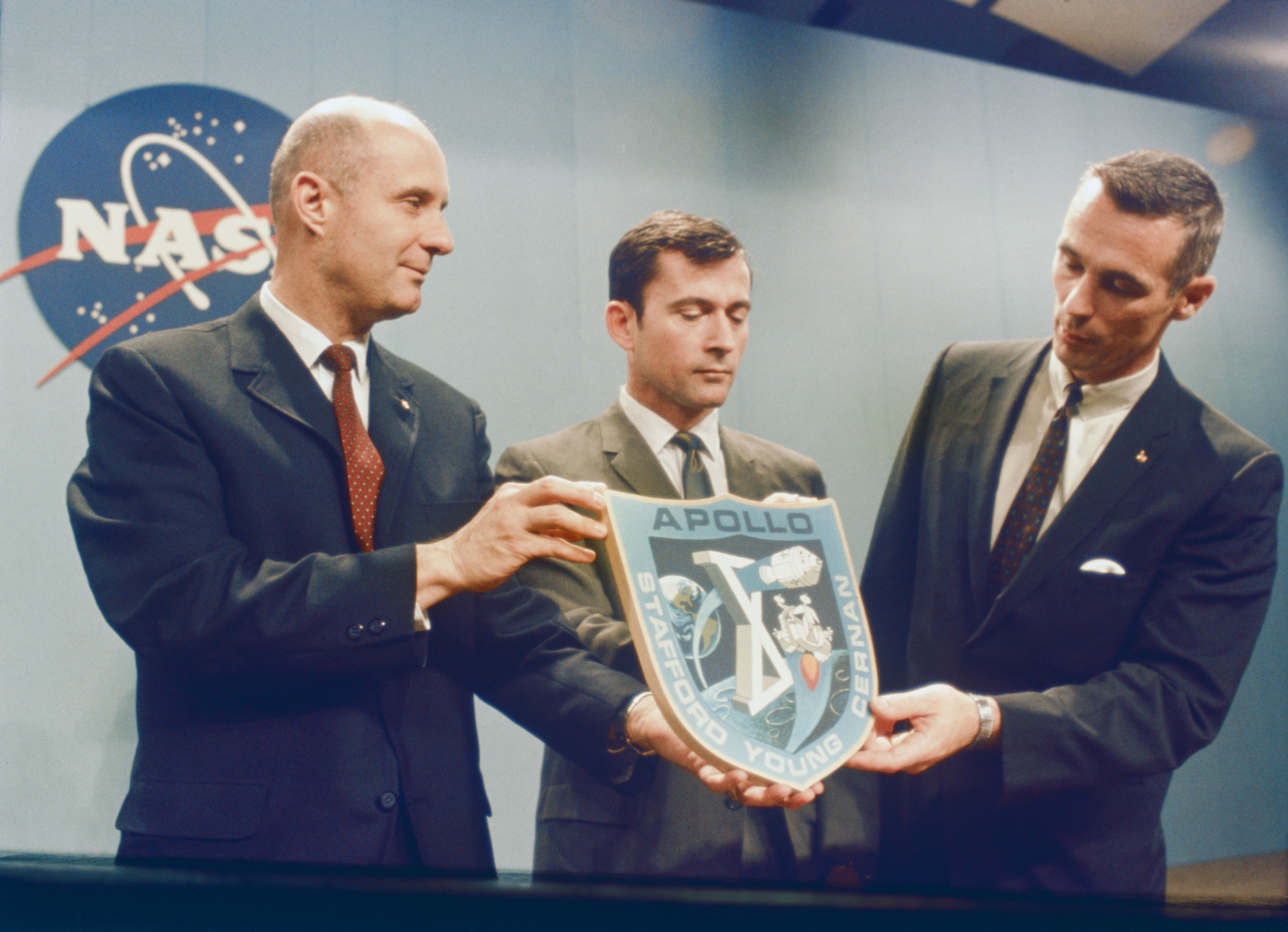 Stafford, left, Young, and Cernan hold their mission patch following a press conference at the Manned Spacecraft Center, now NASA's Johnson Space Center in Houston