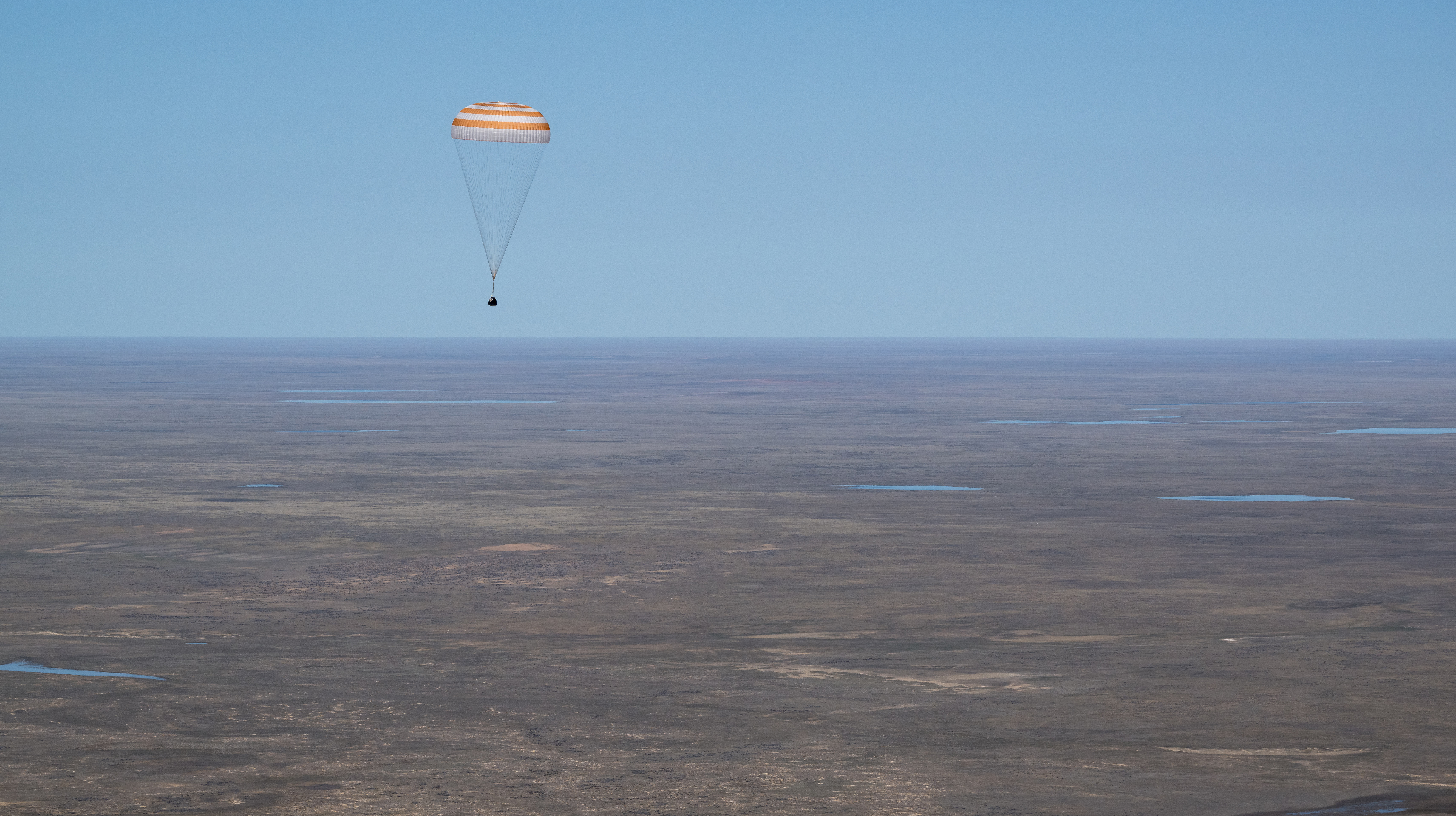 The Soyuz MS-24 spacecraft descends to Earth under its main parachute near the town of Zhezkazgan, Kazakhstan, on Saturday, April 6, 2024. Aboard the Soyuz crew ship were NASA astronaut Loral O'Hara, Roscosmos cosmonaut Oleg Novitskiy, and Belarus spaceflight participant Marina Vasilevskaya who had undocked from the International Space Station several hours earlier. Credit NASA/Bill Ingalls