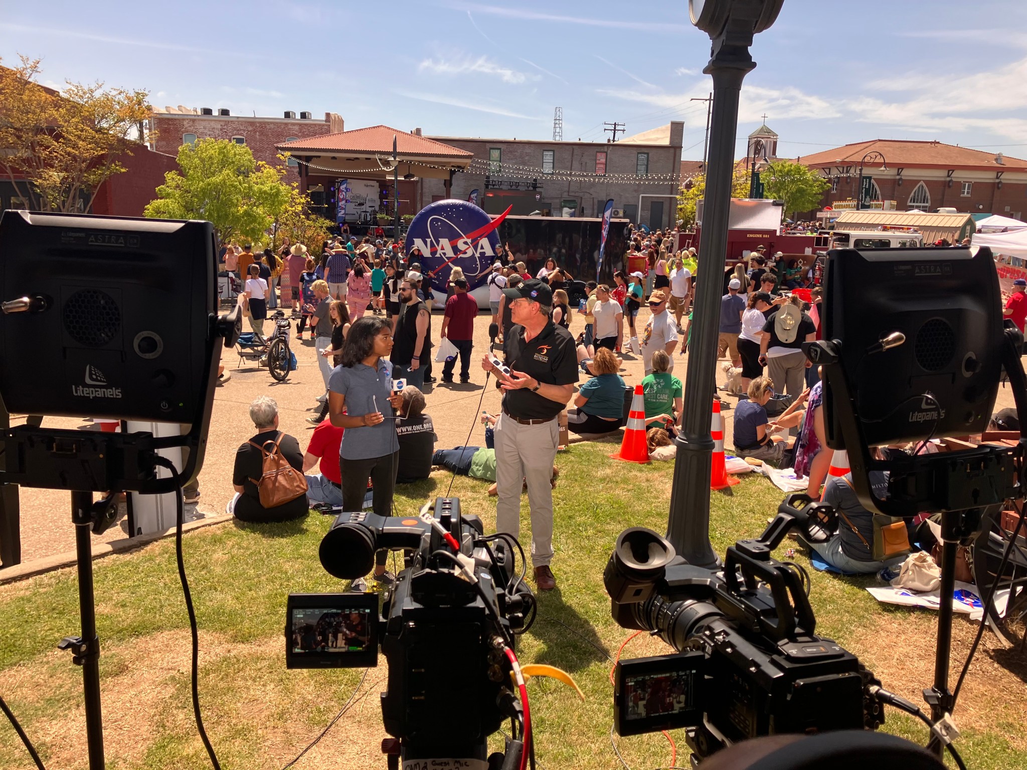 NASA broadcast host Jasmine Hopkins, center left, and NASA Research and Analysis Lead for Heliophysics Patrick Koehn, center right, provide live commentary during the agency's eclipse broadcast from Russellville, Arkansas. The broadcast garnered more than 13 million views by Tuesday afternoon.