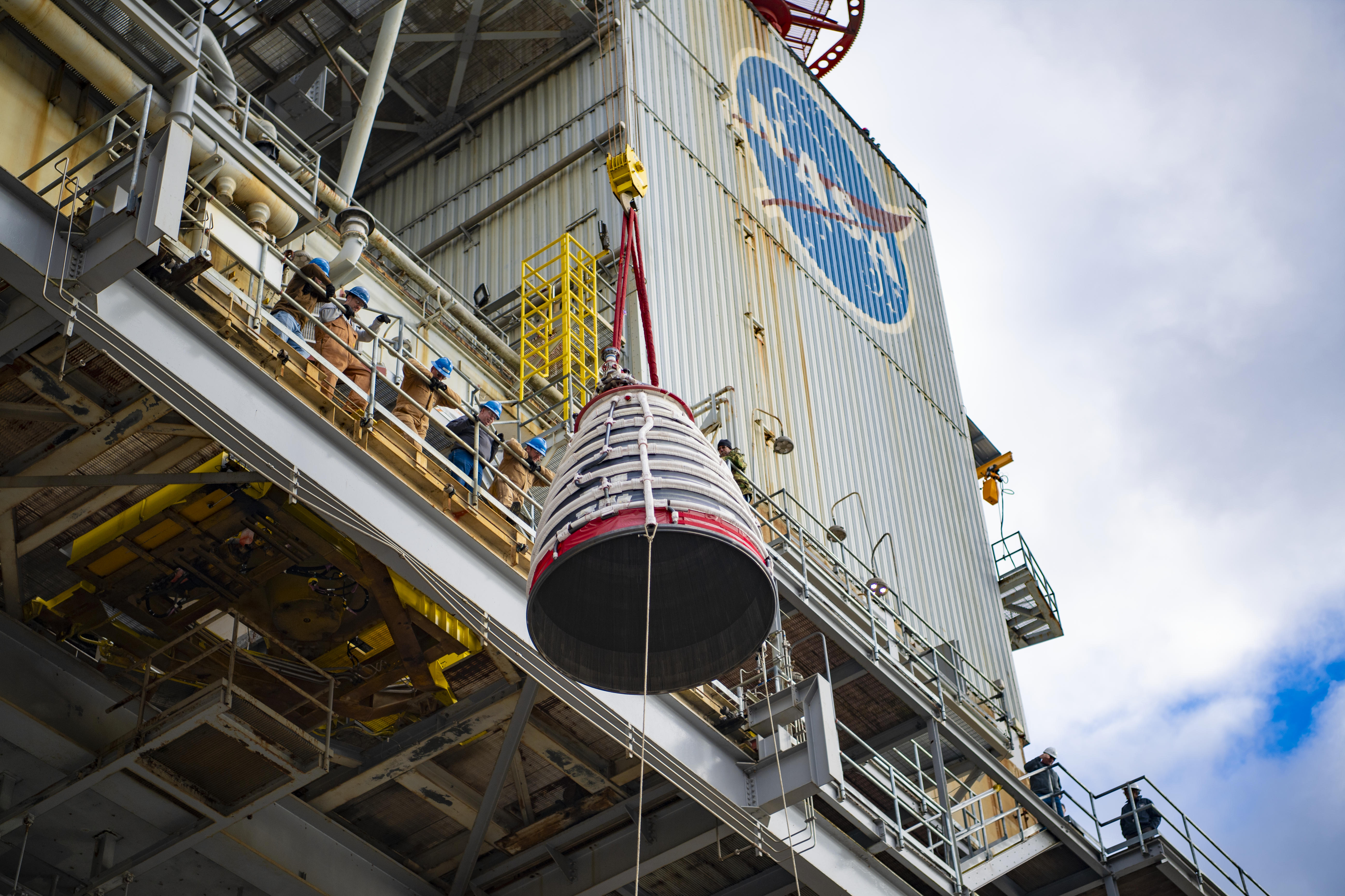 A new RS-25 engine production nozzle is lifted on the Fred Haise Test Stand