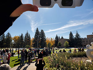 People watching solar eclipse with eclipse glasses.