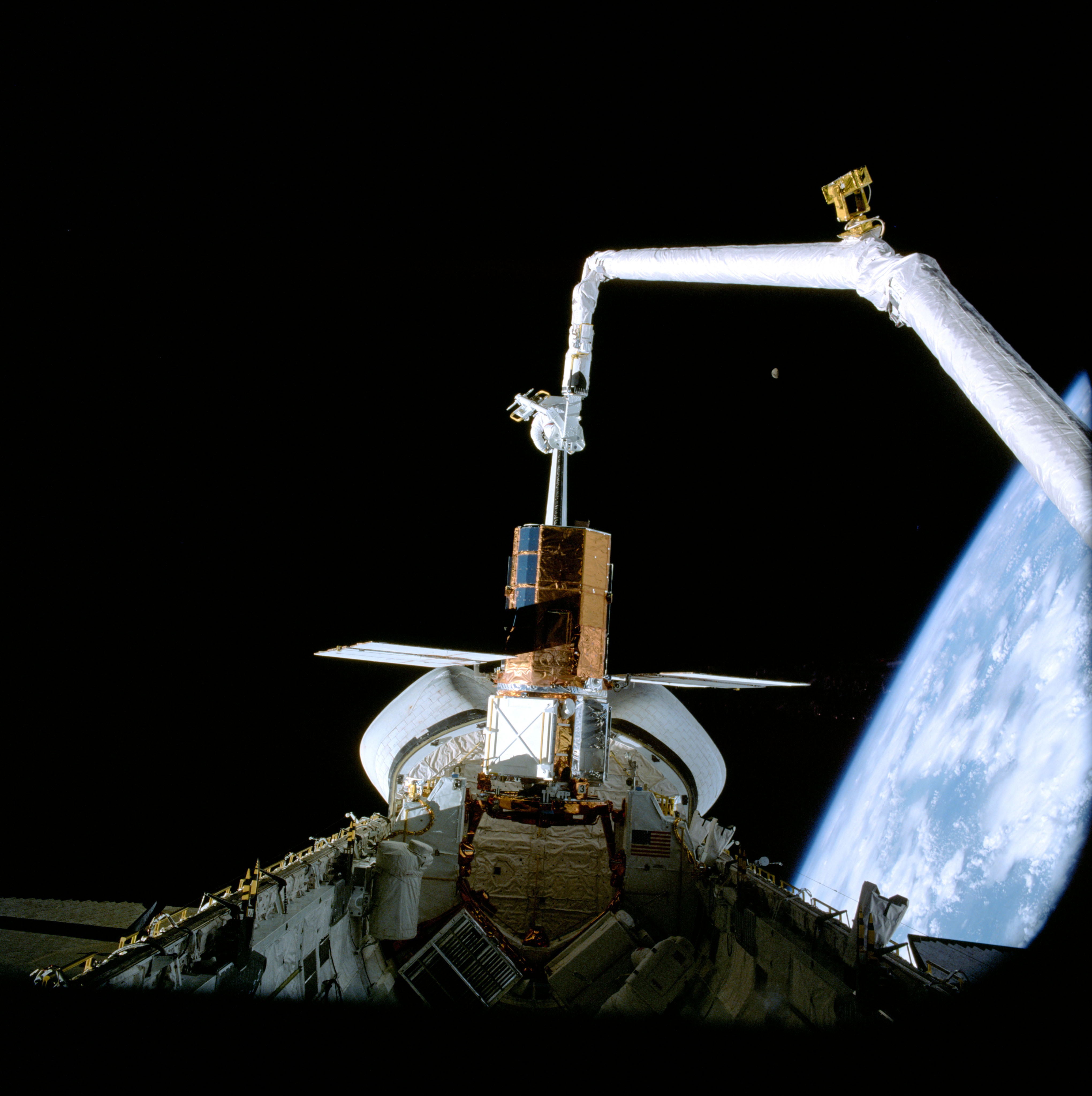 Nelson on the end of the Remote Manipulator System inspects Solar Max