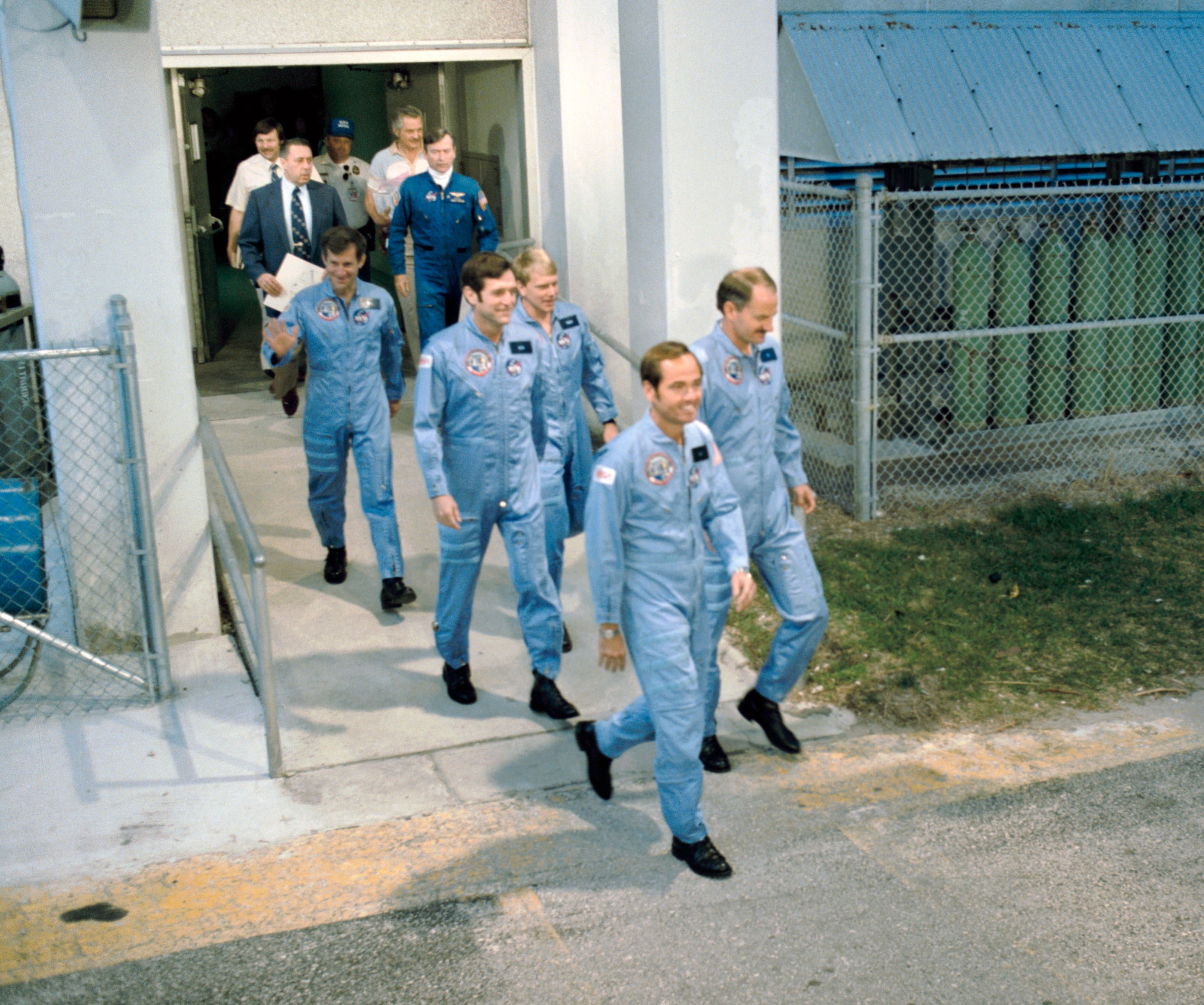 On launch day, the STS-41C astronauts walk out of crew quarters to board the Astrovan for the ride to Launch Pad 39A