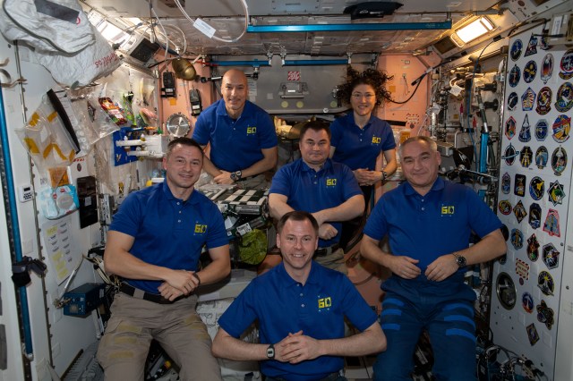iss060e062085 (Sept. 15, 2019) --- The six-member Expedition 60 crew from the United States, Russia and Italy gathers for a portrait inside the International Space Station's Unity module. In the front row from left are, NASA astronauts Andrew Morgan and Nick Hague and Roscosmos cosmonaut Alexander Skvortsov. In the back are, ESA (European Space Agency) astronaut Luca Parmitano, Roscosmos cosmonaut and station commander Alexey Ovchinin and NASA astronaut Christina Koch. On the wall to the right, are stickers representing the insignia of the space shuttle missions that visited the orbiting lab.
