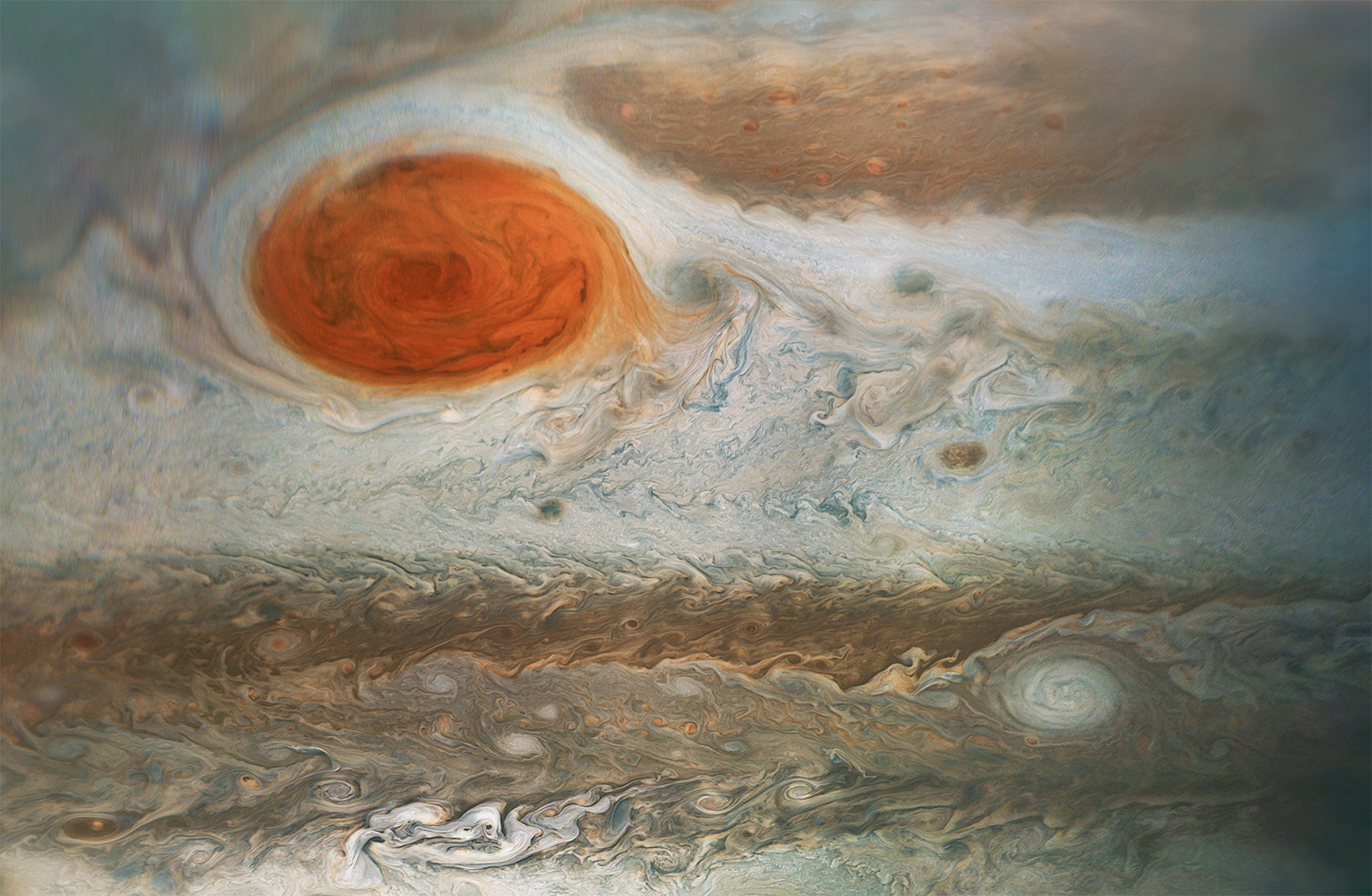 Jupiter's Great Red Spot is at top left of this image taken by NASA's Juno spacecraft. Many smaller storms are visible as well.