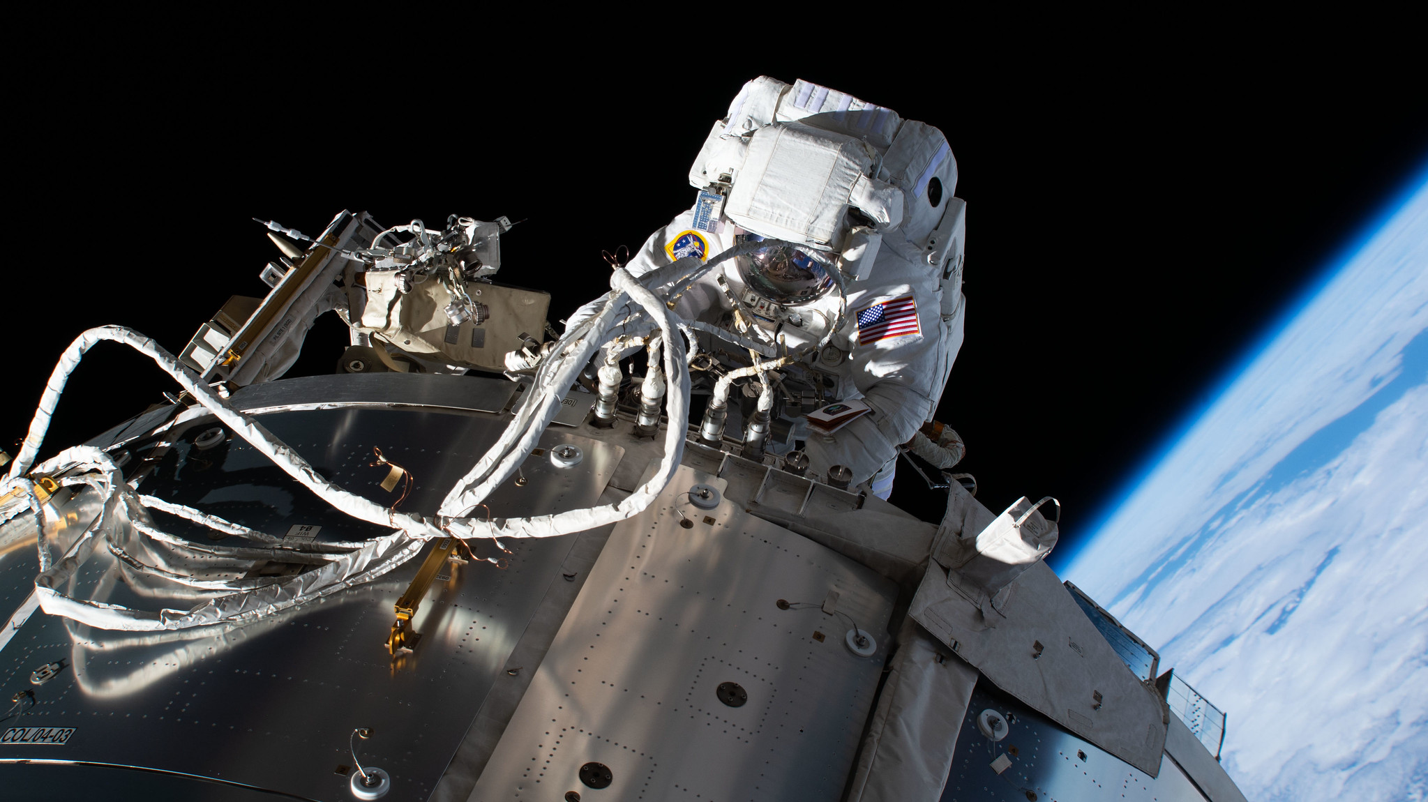 NASA astronaut and Expedition 64 Flight Engineer Michael Hopkins is pictured during a spacewalk servicing communications gear on the outside of the International Space Station's Columbus laboratory module.