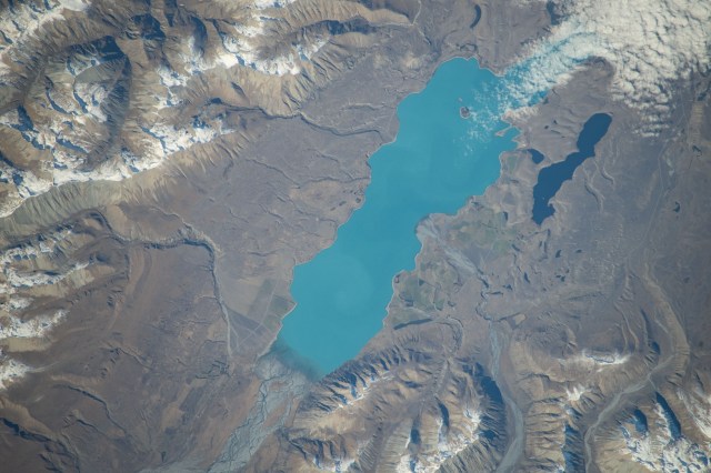 iss071e051532 (May 5, 2024) -- Lake Tekapo's turquoise color contrasts against the surrounding mountains as the International Space Station orbited 266 miles above New Zealand's South Island. Fed by the Godley River, it's one of three nearly parallel lakes in the Mackenzie Basin. Next to it lies Lake Alexandria.