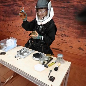 CHAPEA Commander Kelly Haston collects regolith samples during an EVA, or Extravehicular Activity, inside the CHAPEA sandbox. Credit: NASA