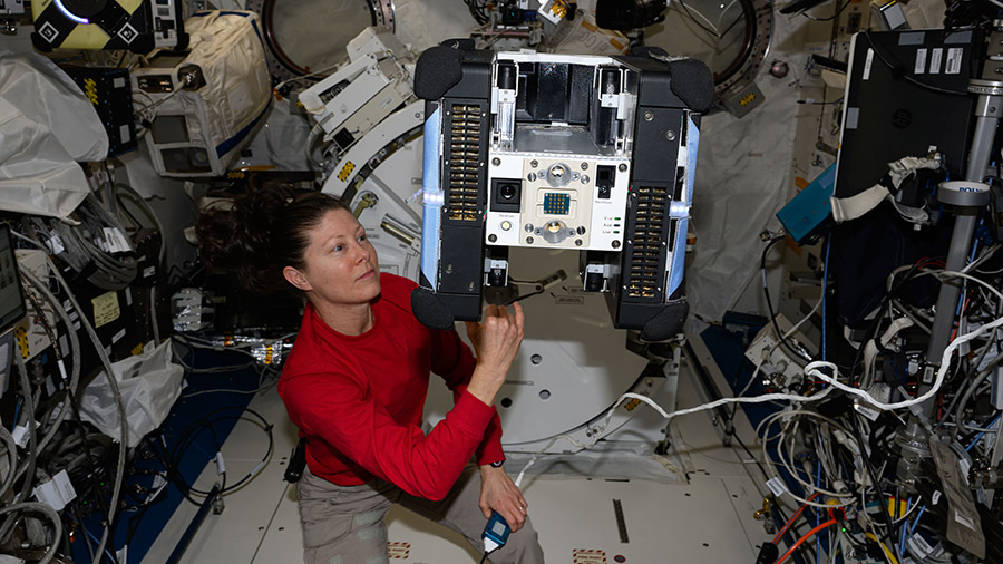 Astronaut Tracy C. Dyson checks out an Astrobee robotic free-flyer for the Zero Robotics, an educational contest, tech demonstration.