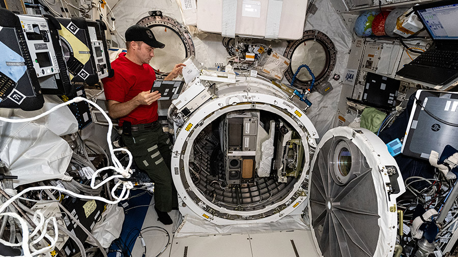 Astronaut Matthew Dominick works in the Kibo laboratory module removing the CubeSat hardware from Kibo's airlock.