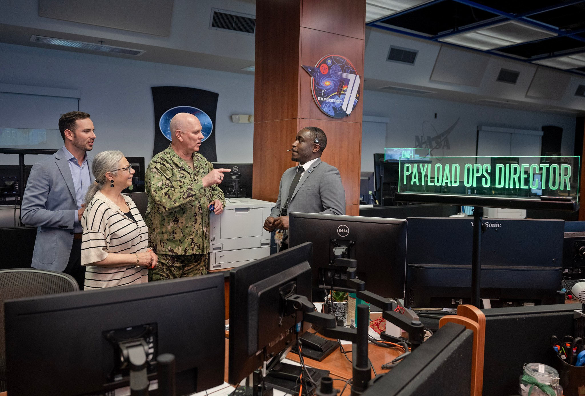 Navy Adm. Christopher Grady, vice chairman of the Joint Chiefs of Staff, his wife Christine Grady, and son Luke Grady talk with Nick Benjamin, right, a payload operations director for the International Space Station, at the Payload Operations Integration Center during the vice chairman’s tour of NASA’s Marshall Space Flight Center on May 6.
