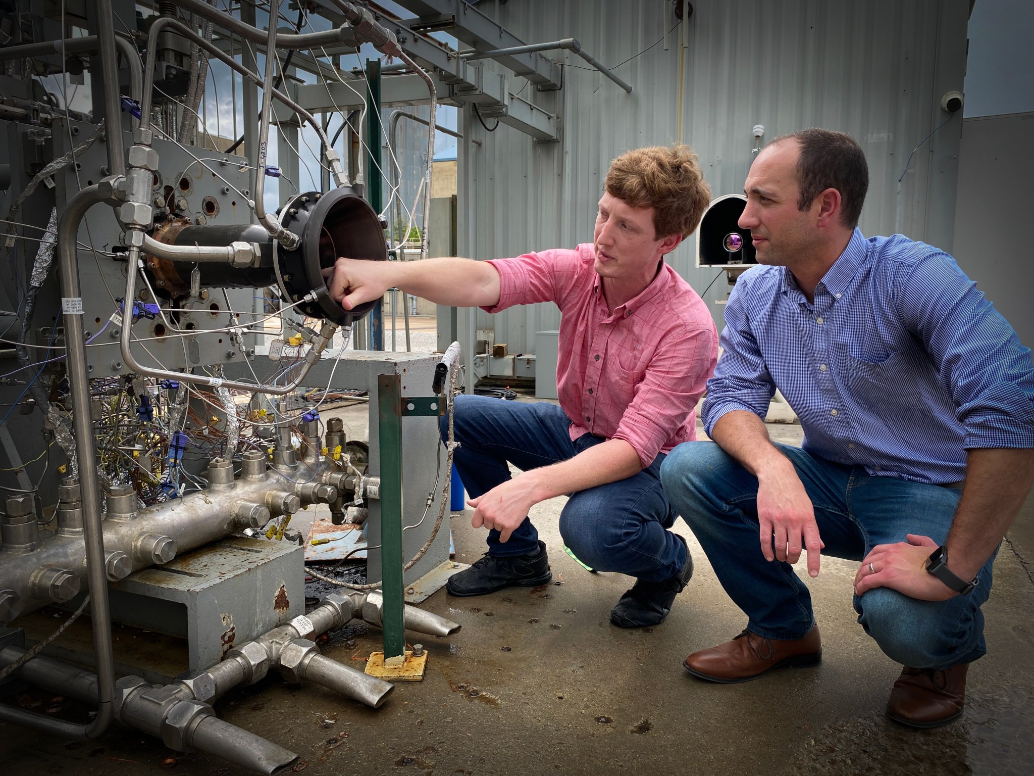 Darren Tinker, left, from NASA’s Marshall Space Flight Center, and Tim Smith, from the agency’s Glenn Research Center, inspect the GRX-810 nozzle and injector following hot-fire testing in 2023 at Marshall.